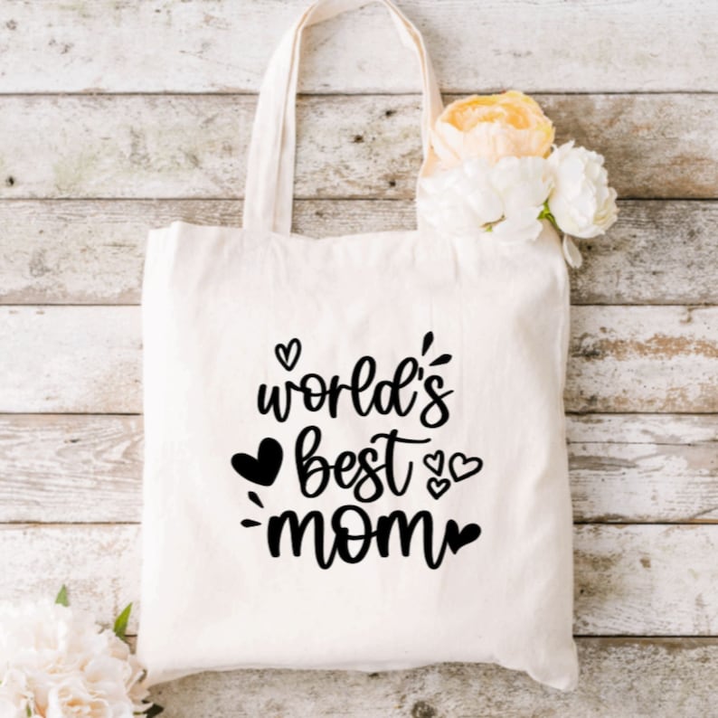 May include: White canvas tote bag with black text that reads "world's best mom" with hearts around the text.