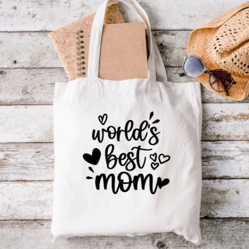 May include: White canvas tote bag with black text that reads "world's best mom" with hearts around the text.