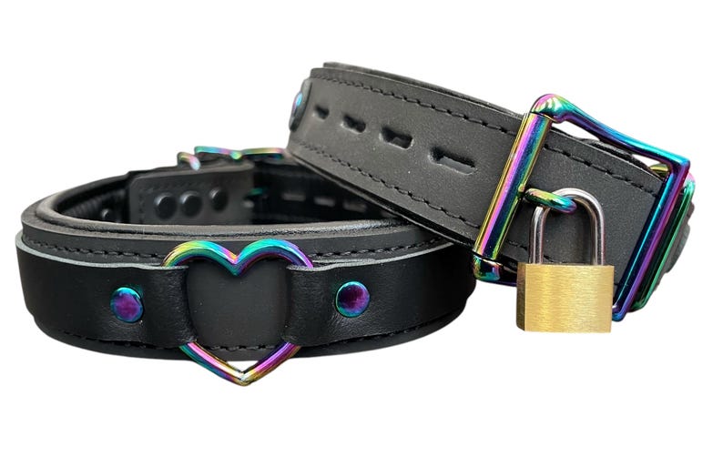 May include: Two black leather collars with rainbow-colored metal hardware. One collar has a heart-shaped cutout and the other has a padlock.