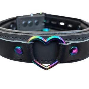 May include: Black leather choker with a rainbow heart-shaped metal accent.