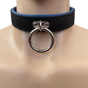 May include: A black leather choker with a blue inner lining and a silver ring. The ring has a small silver loop on top.