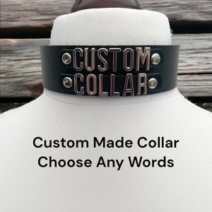 Puede incluir: Un collar de cuero negro con letras de metal plateado que deletrean "CUSTOM COLLAR". El texto "Custom Made Collar Choose Any Words" está escrito debajo del collar.