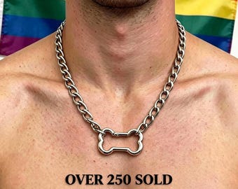 May include: A silver-toned metal chain necklace featuring a central bone-shaped pendant. The necklace is displayed against a background with a rainbow flag. The text "OVER 250 SOLD" is printed in black below the pendant on the image.