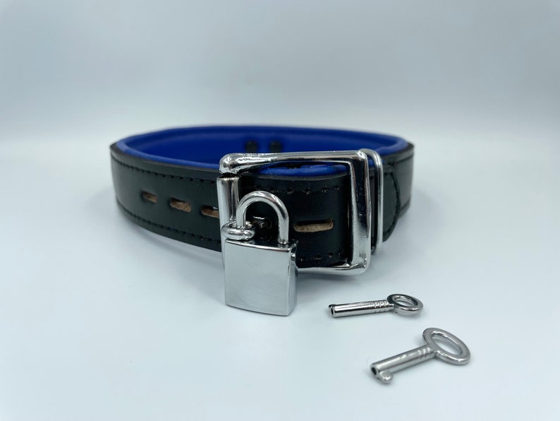 May include: A black leather collar with a blue lining and a silver padlock and two keys.