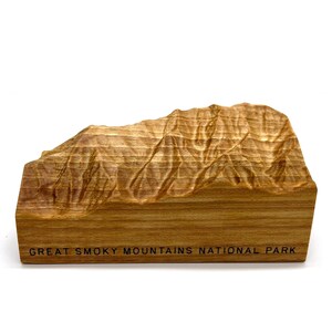 May include: A wooden model of the Great Smoky Mountains National Park. The model is carved in detail and shows the mountain ranges. The base of the model is engraved with the words "Great Smoky Mountains National Park".