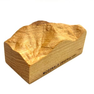 May include: A wooden sculpture of a mountain range with the text "MCDONALD OBSERVATORY" engraved on the base.