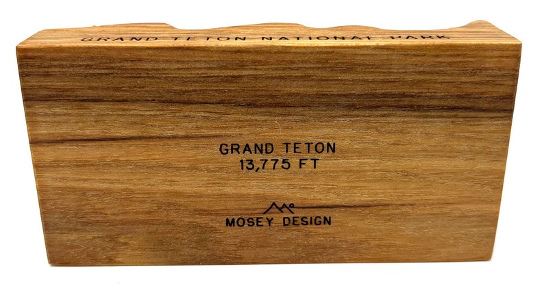 Może przedstawiać: Drewniany blok z tekstem "Grand Teton National Park" i "Grand Teton 13,775 FT" oraz logo "Mosey Design".