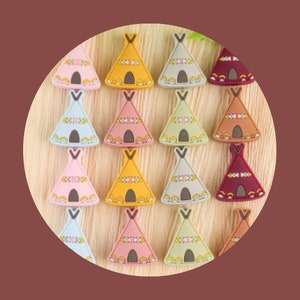 Op de afbeelding: Een verzameling van 15 siliconen bijtringen in de vorm van tipi's in verschillende kleuren, waaronder roze, blauw, geel, groen en bruin. Elke bijtring heeft een ander patroon van geometrische vormen.