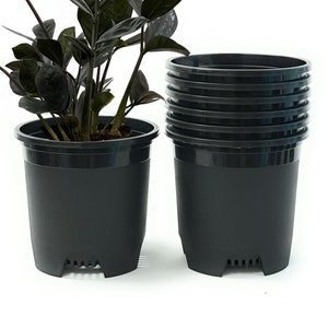 May include: A set of black plastic plant pots with drainage holes. The pots are stacked on top of each other. A houseplant is growing in one of the pots.