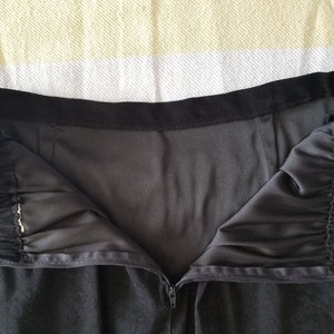 May include: Black skirt with a zipper closure and a black elastic waistband.