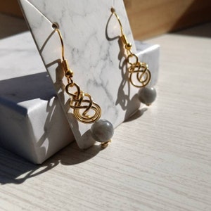 May include: Gold wire earrings with a grey stone bead on each earring.