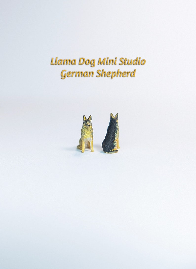 Może przedstawiać: Dwie miniaturowe figurki niemieckich owczark&oacute;w, jedna czarna i brązowa, druga brązowa i beżowa, siedzące na białym tle. Tekst "Llama Dog Mini Studio German Shepherd" znajduje się nad figurkami.