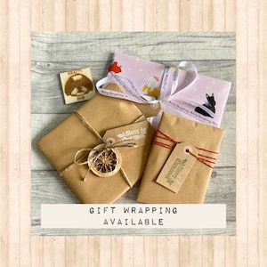 May include: Three rectangular packages wrapped in brown and patterned paper. One package features a dried orange slice and twine, another has red and gold string with a Merry Christmas tag, and the third is tied with Merry Christmas ribbon.