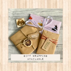 May include: Three rectangular packages wrapped in brown and patterned paper. One package features a dried orange slice and twine, another has red and gold string with a Merry Christmas tag, and the third is tied with Merry Christmas ribbon.