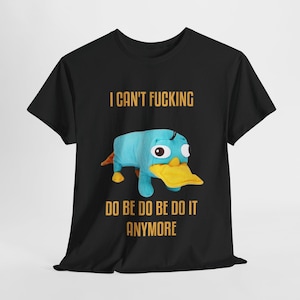 Può includere: T-shirt nera con un cartone animato di ornitorinco con becco e zampe gialle. Il testo "I CAN'T FUCKING DO BE DO BE DO IT ANYMORE" è stampato sopra e sotto il personaggio dei cartoni animati in oro.