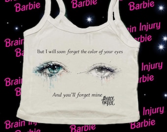 Puede incluir: Camiseta sin mangas blanca con un gráfico de dos ojos de acuarela, uno azul y otro gris, con el texto "But I will soon forget the color of your eyes" y "And you'll forget mine". Las palabras "Brain Injury Barbie" se repiten en los bordes.