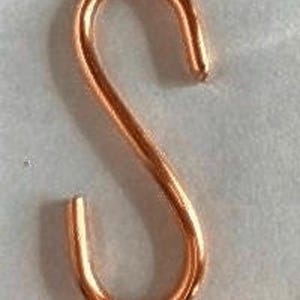 May include: A copper-colored S-shaped hook. The hook is made of metal and has a smooth, shiny finish.