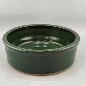 May include: A white ceramic mug with a black handle and the text "But First, Coffee" in a handwritten style. The mug is on a white surface. The mug is 4 inches tall.