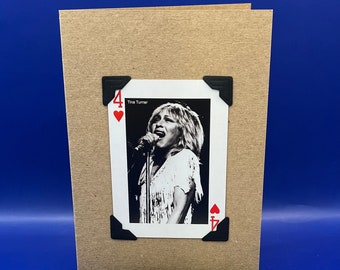 May include: A brown card with a black and white photo of Tina Turner singing. The card is decorated with a black tassel and a black card with the text "KeepSake Card Option Remove the feature card from the front of the greeting card, make a small hole and use the attached tassel to turn it into a bookmark as per this example. Made by DealByTheSea".