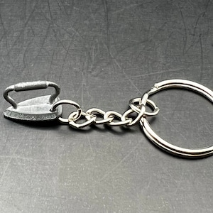 May include: A silver iron keychain with a silver chain and a silver ring.