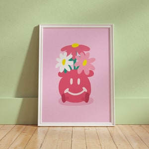 May include: A pink smiling planter with white and pink flowers inside. The planter is on a pink background.