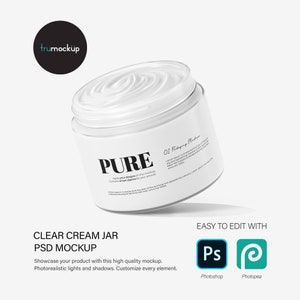 May include: A white cream jar mockup with a white lid and a label that says "PURE" and "Apply your designs on this mockup. Contains smart objects for your artwork." The jar is tilted slightly and has a shadow underneath it.