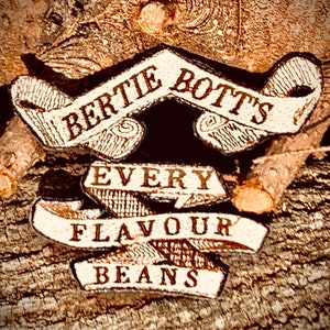 May include: A close-up of a vintage-style, brown and white, fabric banner with the text "Bertie Bott's Every Flavour Beans".