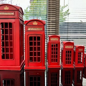 May include: Five red miniature replica telephone boxes of varying sizes, all with the word "TELEPHONE" written on the front.