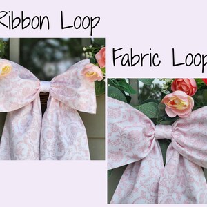 May include: Two side-by-side images showing a bow made of light pink and white floral patterned fabric. The left image is labeled Ribbon Loop and the right image is labeled Fabric Loop. Both bows are attached to a wreath with pink and green flowers.
