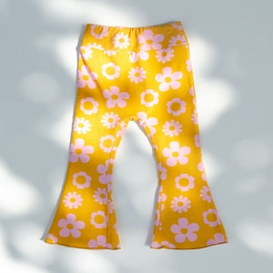 May include: Yellow bell bottom pants with a pink floral pattern.