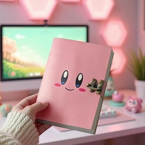 Puede incluir: Un diario rosa con un diseño de cara de dibujos animados y un cierre de broche. El diario se sostiene frente a un escritorio con una computadora, una lámpara en forma de luna y otros elementos decorativos. El fondo presenta luces rosas en forma de hexágono.