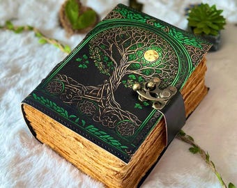 May include: A green leather-bound journal with a gold tree of life design and a brass clasp. The journal has a rustic, aged look and is perfect for writing down thoughts, dreams, or spells.