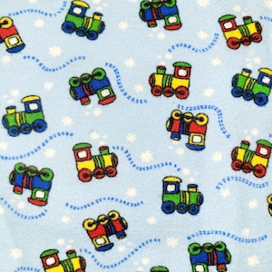 May include: A blue fabric with a repeating pattern of colorful toy trains. The trains are yellow, green, red, and blue with black wheels. The background is light blue with white stars.