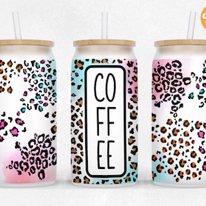Puede incluir: Tres vasos de acero inoxidable con diseño de estampado de leopardo. Los vasos tienen una tapa de bambú y una pajita. Un vaso tiene la palabra "COFFEE" escrita en él.