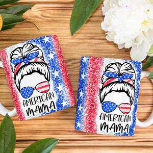 May include: Two white ceramic mugs with red, white, and blue glitter designs. The mugs feature a woman with a messy bun and sunglasses. The text "AMERICAN MAMA" is printed on each mug.