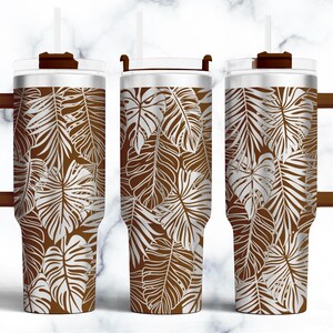 May include: A stainless steel tumbler with a brown and white tropical leaf pattern. The tumbler has a lid and a straw.