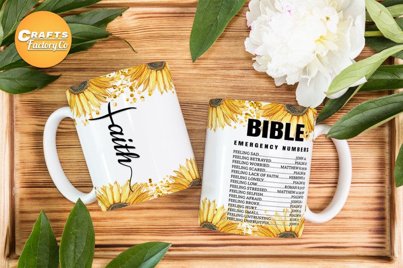 May include: Two white ceramic mugs with sunflower designs. One mug says "faith" and the other says "Bible Emergency Numbers" with a list of Bible verses for different feelings.