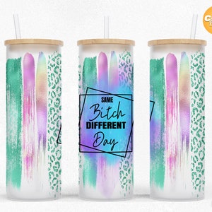 Puede incluir: Un vaso de vidrio con tapa y pajita de bambú. El vaso presenta pinceladas verticales en verde azulado, rosa y colores iridiscentes, con un estampado de leopardo verde. El texto "SAME Bitch DIFFERENT Day" se muestra en un marco negro.
