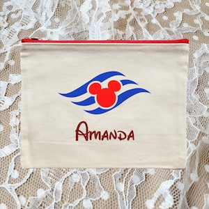 May include: A white canvas zippered pouch with a red zipper. The pouch has a blue and red Mickey Mouse head with waves and the name Amanda in red glitter.