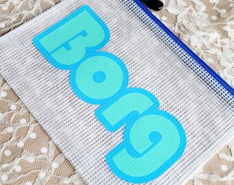 Puede incluir: Una bolsa de malla blanca con cremallera azul. La bolsa tiene la palabra "BORG" impresa en letras grandes de color turquesa.