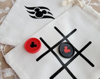 May include: Two white fabric bags with black and red Mickey Mouse designs. One bag has a noughts and crosses board with black lines and red and black game pieces. The other bag has a Mickey Mouse head with a wave design.