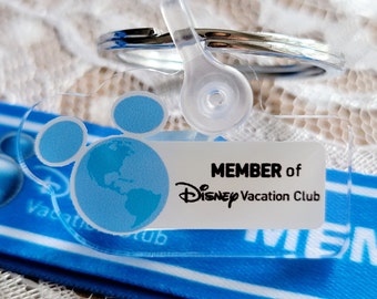 May include: A clear plastic keychain with a blue Mickey Mouse head and a globe design. The keychain says "MEMBER of DISNEY Vacation Club".