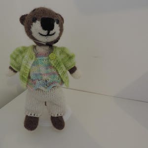 Hand-knitted otter (23 cm) and its wardrobe