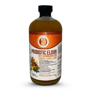 Puede incluir: Una botella de vidrio de elixir probi&oacute;tico con t&eacute; kombucha, c&uacute;rcuma, jengibre y lim&oacute;n. La botella es naranja y amarilla con una etiqueta que dice "This Chick is Raw" y "Probiotic Elixir with Kombucha Tea".