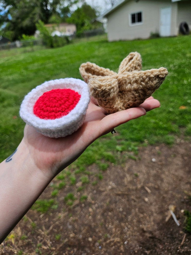 May include: Two crocheted amigurumi toys. One is a red and white mushroom, the other is a brown star.