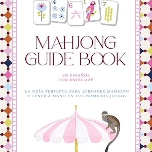 May include: A Mahjong Guide Book with the text "American Mahjong" at the top. The cover features illustrated Mahjong tiles, a pink and white striped umbrella, and a monkey. The book is in Spanish.