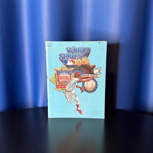 May include: A light blue World Series 1981 program. The cover features a baseball player in action, a baseball, and an eagle. The text includes "World Series 1981", "National League", and "American League".