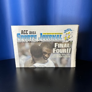 May include: A newspaper headline reads "Final Four!!" with a photo of two basketball players embracing. The newspaper is titled "ACC Area Sports Journal" and the text "ACC Has Put 26 Teams In Last 25 NCAA Semifinals" is also visible.