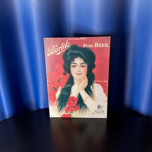 May include: Vintage Bartels Pure Beer metal sign featuring a woman with long dark hair and red poppies. The sign has a red background with the text "Bartels" and "Pure Beer". The sign is from 1909.