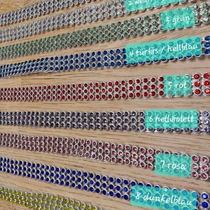 Pu&ograve; includere: Dieci file di catene argentate con strass di diversi colori. Le catene sono numerate da 1 a 10, con il colore corrispondente degli strass. I colori sono bianco, arcobaleno, verde, turchese, rosso, lilla chiaro, rosa, blu scuro, giallo e nero.